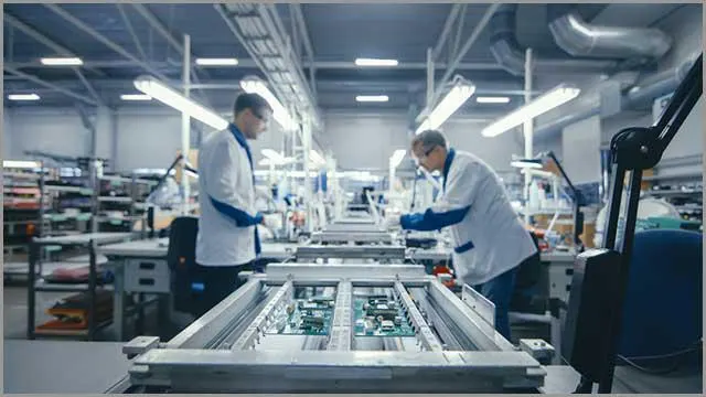 (Pracownicy fabryki montujący PCB)