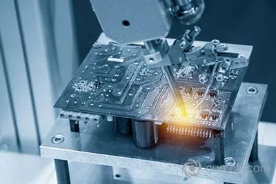 Robot spawający lutuje płytkę drukowaną w jasnoniebieskiej scenerii z efektami świetlnymi.