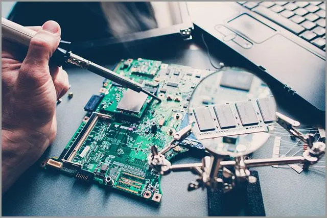 Technik naprawiający układ pcb za pomocą lutownicy